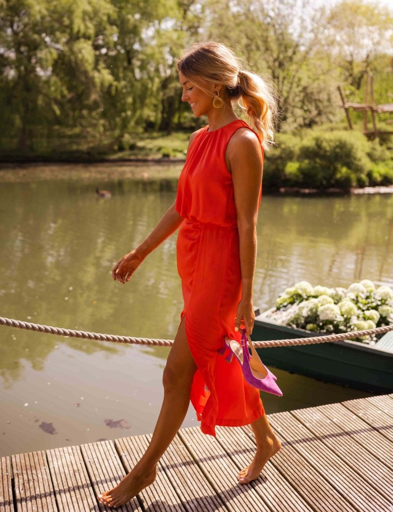 Red sleeveless midi dress with gathered waist, side slit, flowing fabric