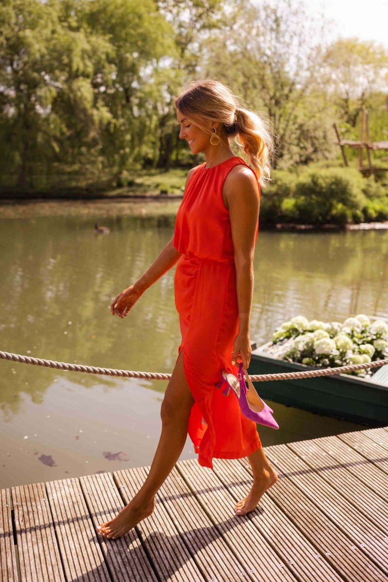Red sleeveless midi dress with gathered waist, side slit, flowing fabric
