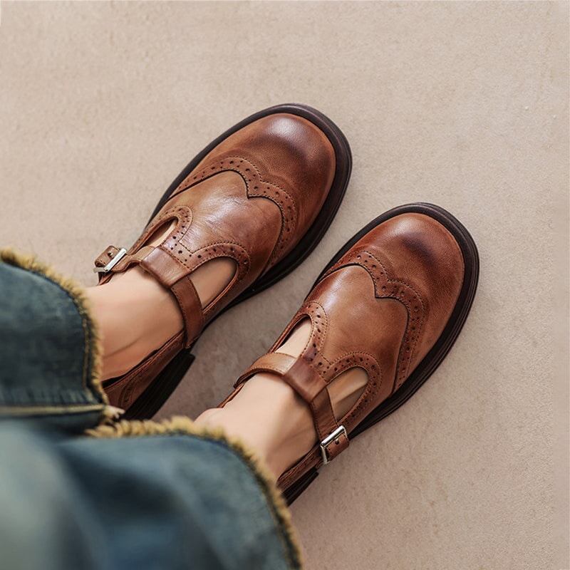 Brown Mary Jane shoes with buckle strap and wingtip-style detailing