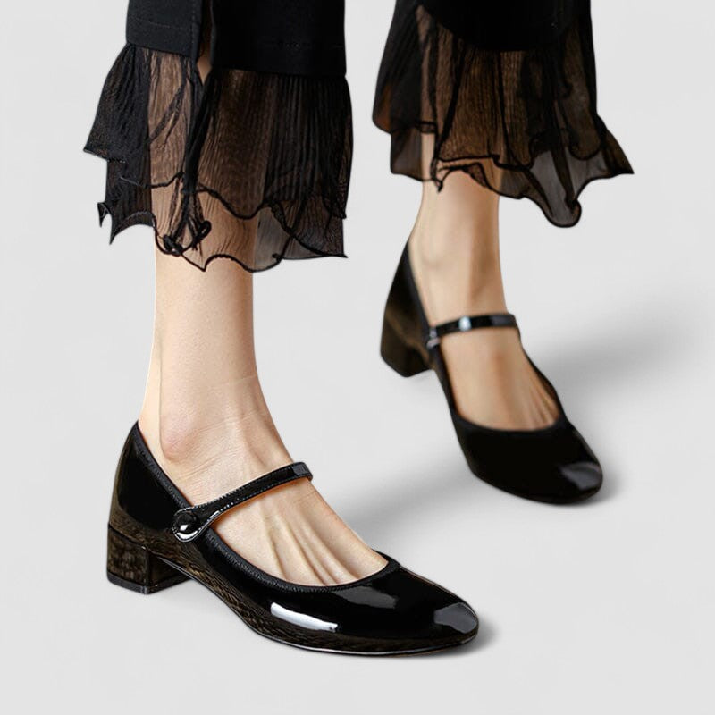 Black Mary Jane shoes with glossy finish and ankle strap, chunky block heel.