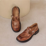 Brown Mary Jane loafers with buckle strap, cutout detailing, and chunky sole