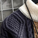 Cable-knit navy textured panel with cream ribbed collar and black cord trim