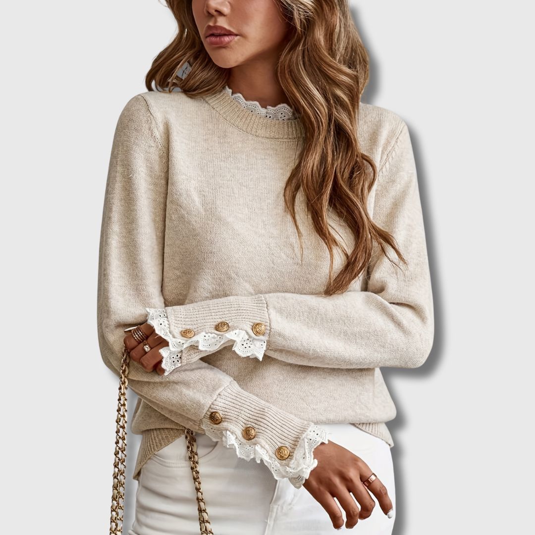 Beige crewneck knit sweater with white lace cuff trim and round button accents