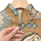 Women's knit jacket close-up: tan fabric, horse print, metal zipper pull.