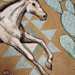 Horse graphic on women's knit jacket, tan background with blue cactus shapes.