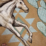 Horse graphic on women's knit jacket, tan background with blue cactus shapes.