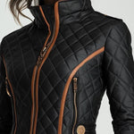 Black quilted padded jacket close-up with stand collar, front zipper and tan piping
