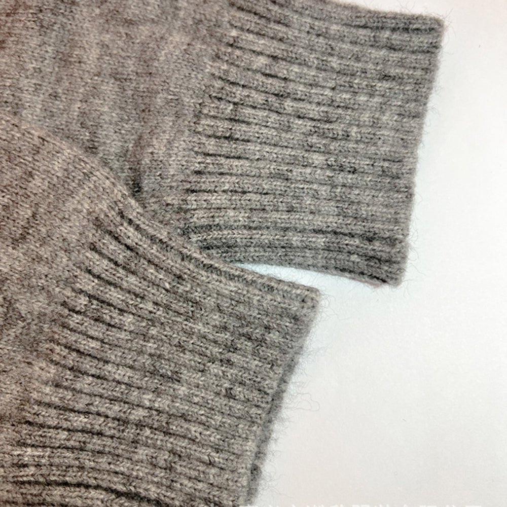 Gray knit cardigan sleeve cuff close-up with ribbed knit texture