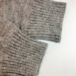 Gray knit cardigan sleeve cuff close-up with ribbed knit texture