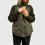 Olive green quilted jacket with zip front and ribbed knit sleeves