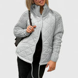 Light gray quilted jacket with zip front and ribbed knit sleeves