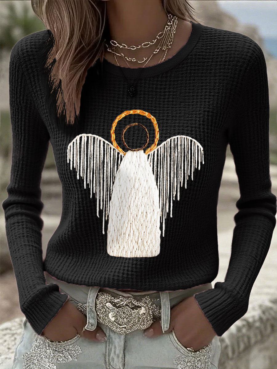 Black knit sweater with angel nativity graphic and wing detail, long sleeves