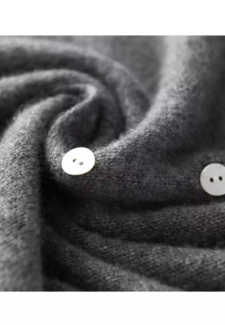 Dark gray knit sweater with round white buttons and folded button placket