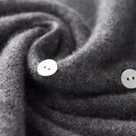 Dark gray knit sweater with round white buttons and folded button placket