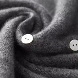 Dark gray knit sweater with round white buttons and folded button placket