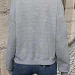 Grey long-sleeve bomber jacket, back view, textured chevron knit and ribbed hem.