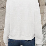 White bomber jacket, back view, textured chevron knit and ribbed hem.