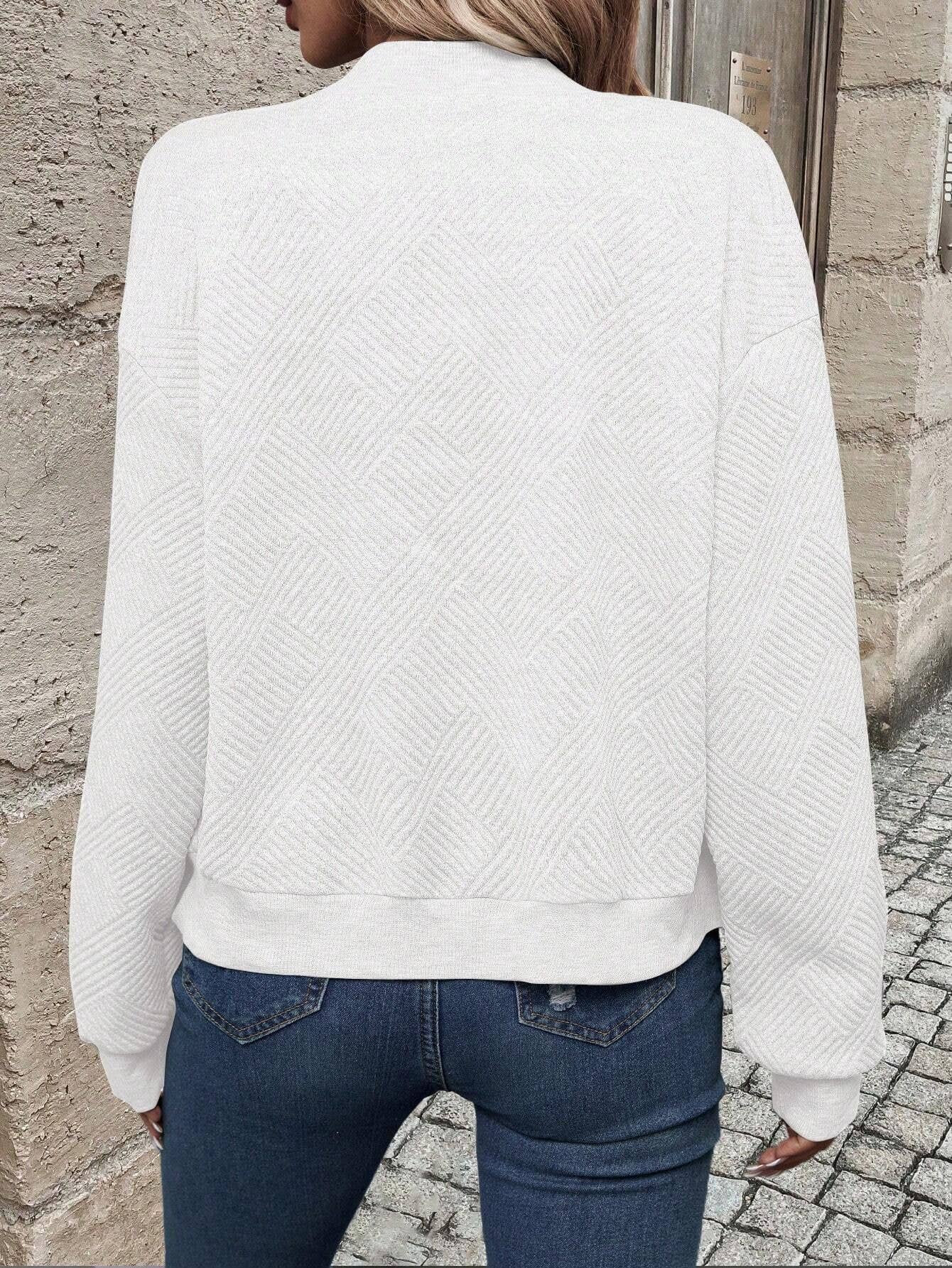 White bomber jacket, back view, textured chevron knit and ribbed hem.