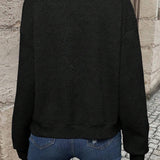 Black bomber jacket, back view, textured chevron knit and ribbed hem.